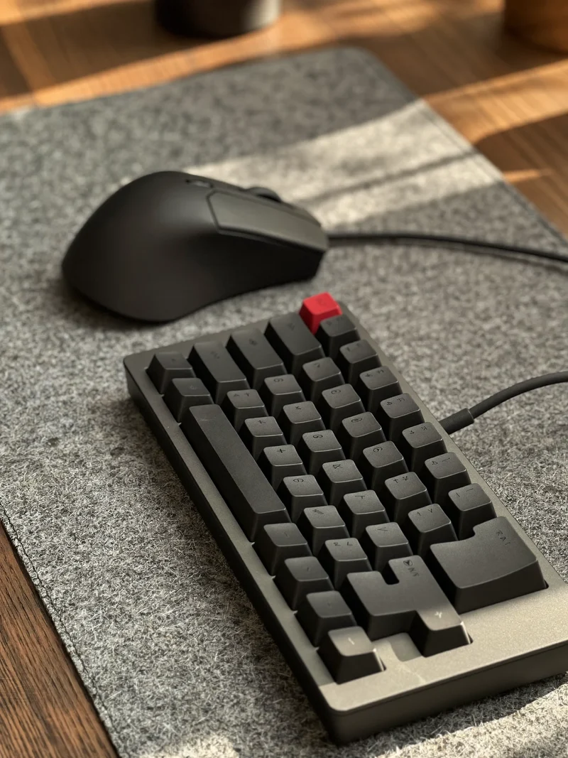 Kompaktní mechanická klávesnice a ergonomická myš na plstěné podložce, pohled shora